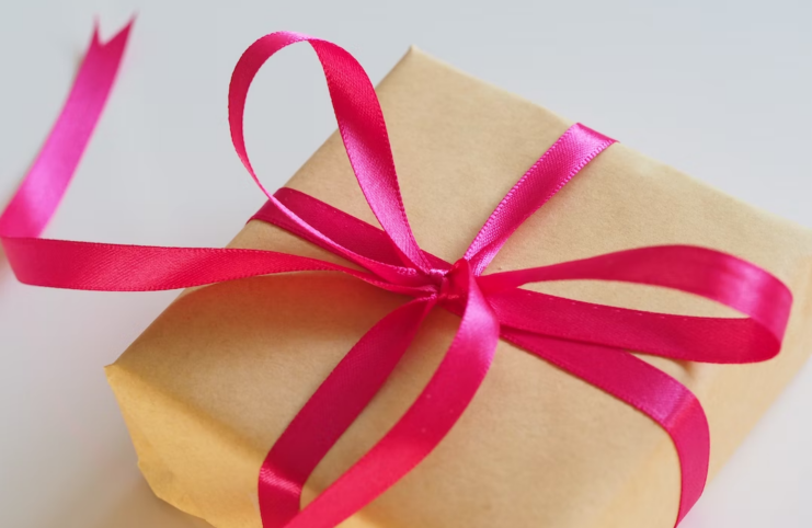 A gift wrapped with a magenta ribbon. Depiction of perfect gifts